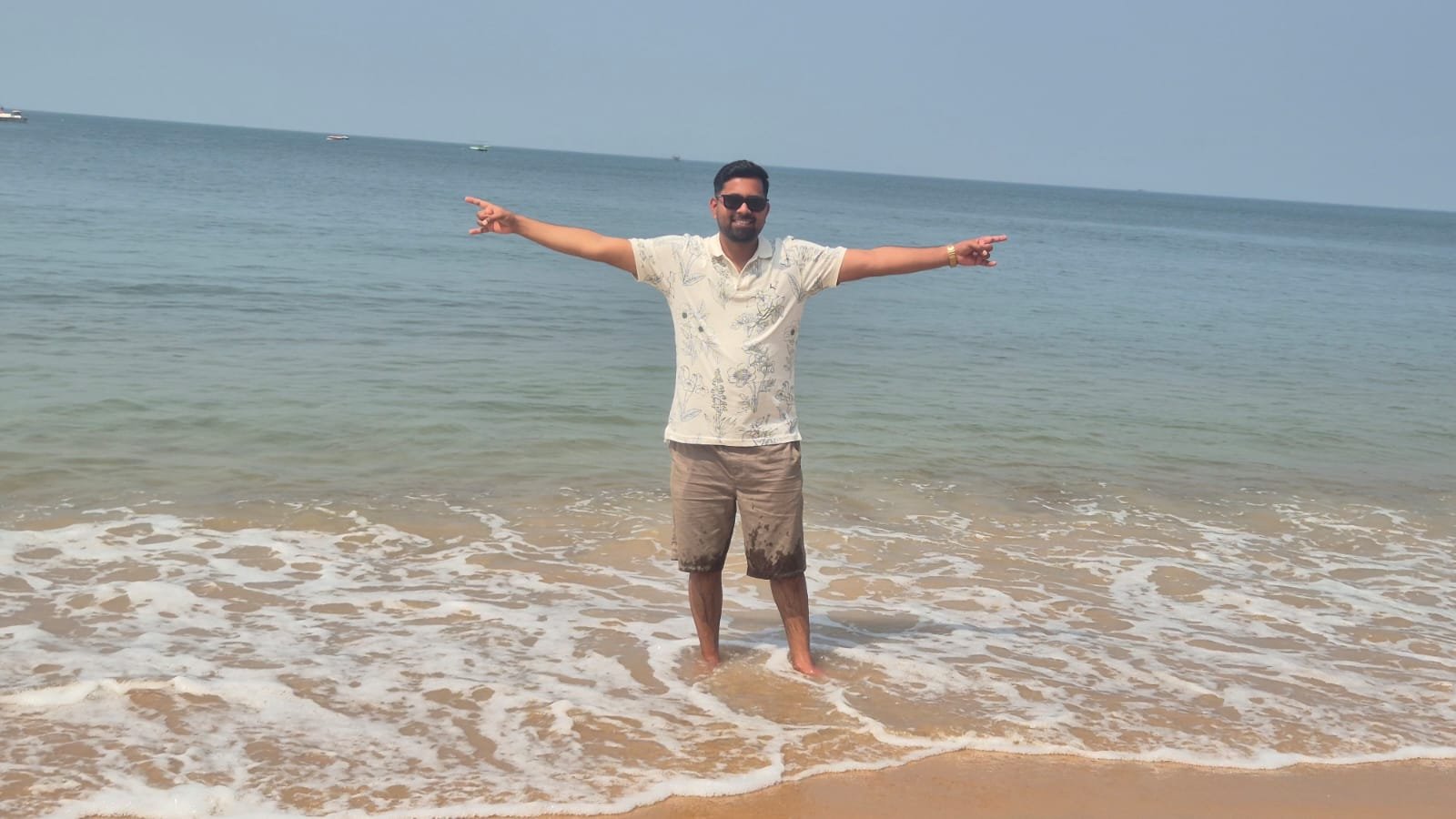 Siona Tours traveller standing in the waves on a sandy beach