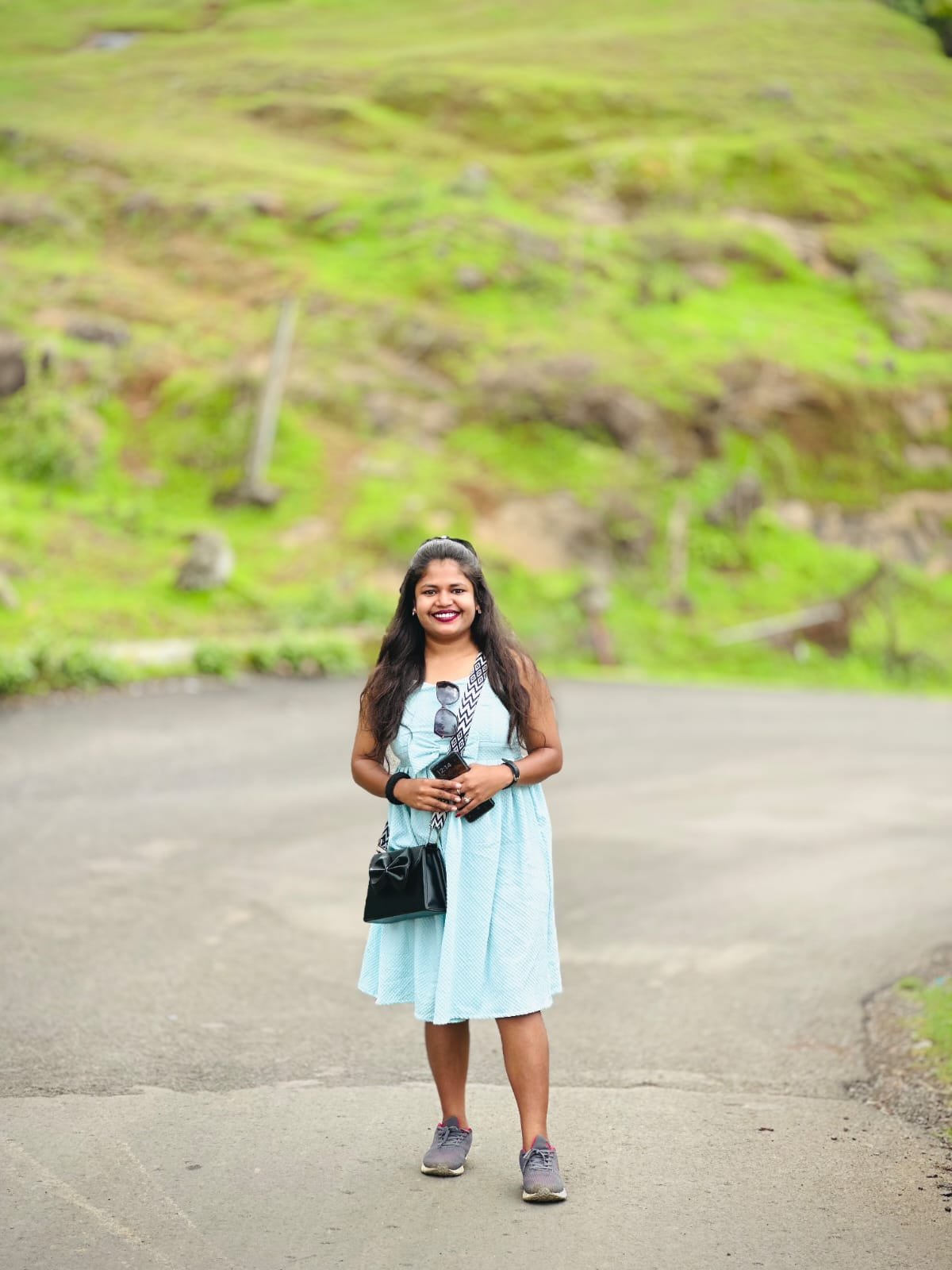Smiling Siona Tours traveller on a mountain road with green hills behind