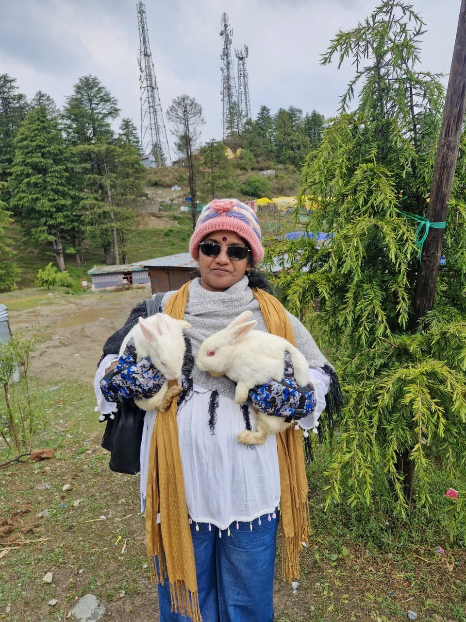 Siona Tours traveller holding two white rabbits at a hill-station stop