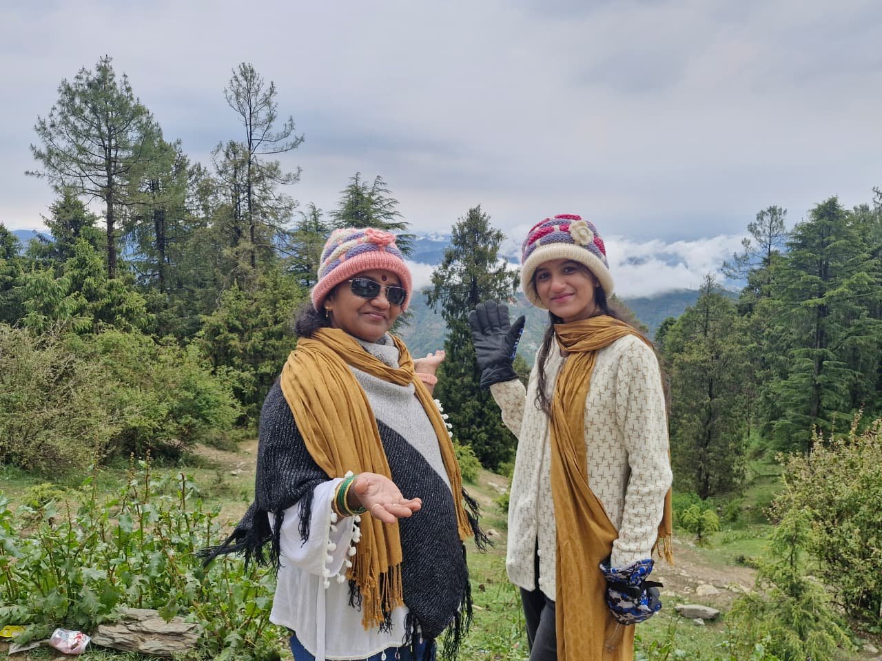 Two Siona Tours travellers in woollen caps among pine trees with misty mountains behind